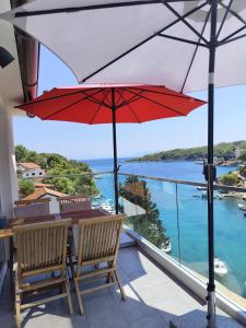 a patio with a table and two chairs and an umbrella at Summer House Krištof in Vrbanj