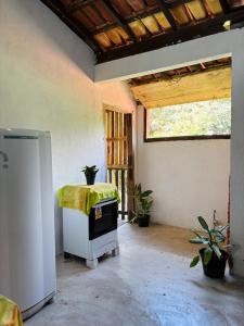 a living room with a stove and a window at Aroeira Suite in Conceição da Barra