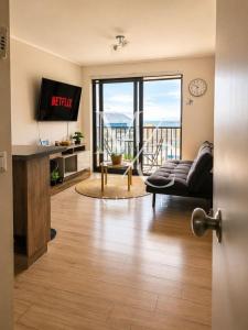 a living room with a couch and a tv at Deptos Estudios y de 2 dormitorios, Central, San Martin 2426. Sector Mall Plaza, Cowork y Factura. in Antofagasta