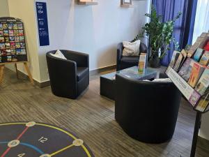 a room with two chairs and a tv in a store at ibis budget Aix en Provence in Aix-en-Provence