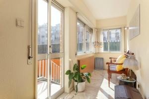 a room with large windows and a table and a plant at 18St. Hostel in Espinho
