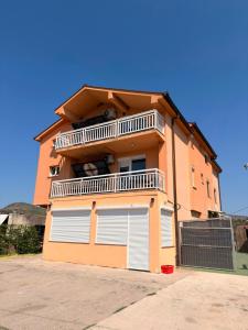 a building with two garage doors and a balcony at Apartmani Ana in Čapljina