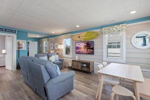 a living room with blue walls and a table and chairs at 4119 - The Dolphin Boat in Kitty Hawk