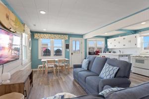 a living room with a couch and a kitchen at 4119 - The Dolphin Boat in Kitty Hawk