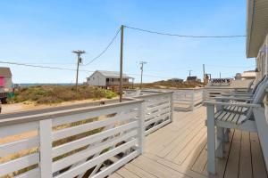 a bench sitting on a deck looking at the beach at 4119 - The Dolphin Boat in Kitty Hawk