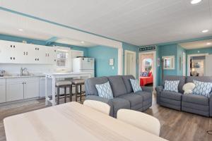a living room with two couches and a kitchen at 4119 - The Dolphin Boat in Kitty Hawk