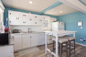 a kitchen with white cabinets and a white refrigerator at 4119 - The Dolphin Boat in Kitty Hawk +22 photos