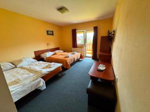 a hotel room with two beds and a window at Penzión Timea Zuberec in Zuberec