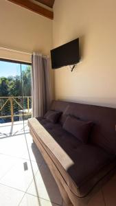 a large bed in a room with a flat screen tv at Pousada Aquarela de Bombinhas in Bombinhas
