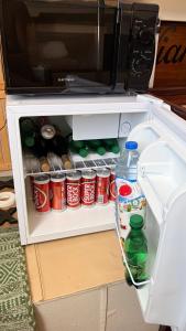 an open refrigerator filled with cans and bottles of soda at Viana Sealife in Viana do Castelo