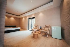 a room with a refrigerator and chairs and a bed at Hotel Casino Elite in Quiévrain