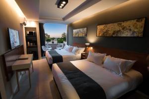 a hotel room with two beds and a balcony at Pinares Panorama Suites, Spa & Convention Center in Villa Carlos Paz