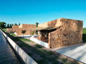 a stone building next to a body of water at Rincon del Malbec in Ciudad Lujan de Cuyo