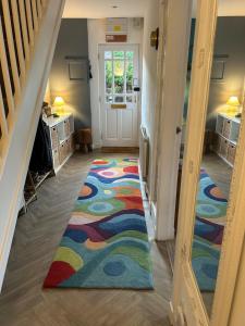 a hallway with a colorful rug on the floor at Four Seasons B&B, Ground floor room, private bathroom, 3rd floor loft living area & self serve continental breakfast in Pitlochry