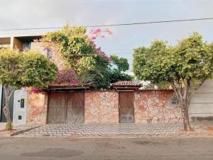 a stone building with trees and flowers on it at Casa do Mandacaru in Bom Jesus da Lapa