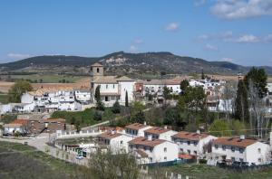 a town with white houses and mountains in the background at Casona del Tajuña in Armuña de Tajuña