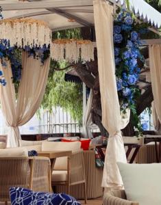 a restaurant with blue and white curtains and tables at РАДУГА Иссык-Куль in Chon-Sary-Oy