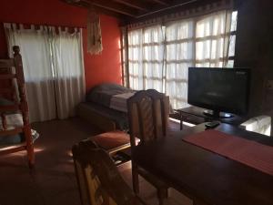 a living room with a television and a table with a dining room at Posada Valentina in San Salvador de Jujuy