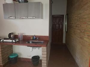 a kitchen with a sink and a brick wall at Posada Valentina in San Salvador de Jujuy