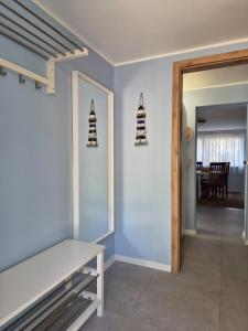 a room with a white bench and a dining room at Apartament "Przez las na plażę" in Świnoujście