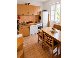 a kitchen with a table and a white refrigerator at Apartmani KaLu in Mlini