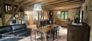a living room with a black couch and a table at La Longère en Puisaye, 2 gîtes à 10 min de Guédelon réservables ensemble et séparément in Dampierre-sous-Bouhy +21 photos
