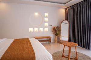 a bedroom with a bed and a stool and a mirror at Montelago Batur in Bangli
