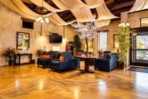 a lobby with blue chairs and a table and a tv at Comfort Inn Pomona near Fairplex in Pomona