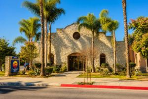 a building with palm trees in front of a street at Comfort Inn Pomona near Fairplex in Pomona