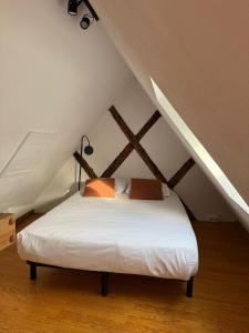 a bedroom with a white bed in the attic at Les Appartements de Home Petite Venise in Colmar