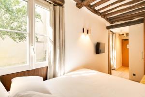 a bedroom with a bed and a window at Hotel Murmures Notre-Dame in Paris