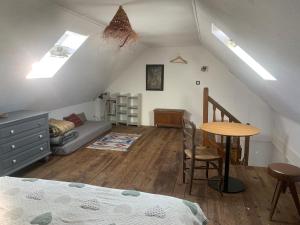 a attic room with a bed and a table at Ti Bihan in Plouguerneau