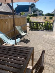 two chairs and an umbrella on a patio at Ti Bihan in Plouguerneau