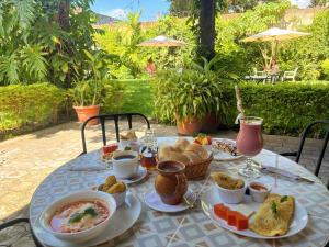 a table with a breakfast of soup and bread at Alana Hotel By ISH in Antigua Guatemala