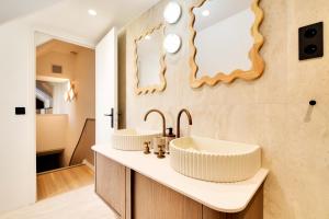 a bathroom with two sinks and a mirror at Hotel Murmures Notre-Dame in Paris +64 photos