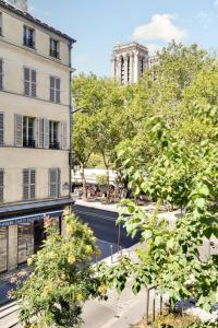 a view of a street with a building and trees at Hotel Murmures Notre-Dame in Paris