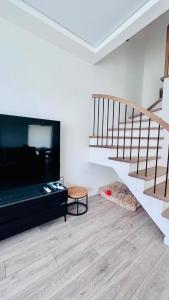 a living room with a staircase and a couch at Ungura Nord in Mozūriškiai