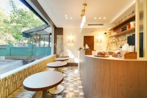a restaurant with a row of tables and a counter at Hotel Murmures Notre-Dame in Paris