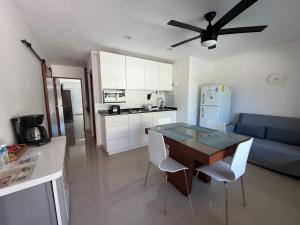a kitchen and living room with a table and a blue couch at Brisas Shores Beachfront connecting apartments, Cancun Hotel Zone in Cancún