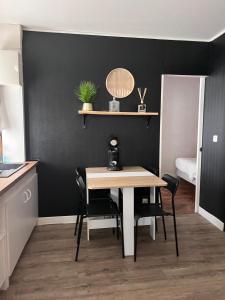 a table and chairs in a room with a black wall at Apparemment jacuzzi balnéo centre de Bordeaux in Bordeaux