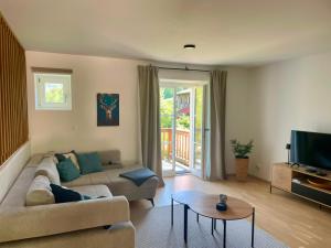 a living room with a couch and a tv at Ferienwohnung Alpenherz Berchtesgaden in Berchtesgaden