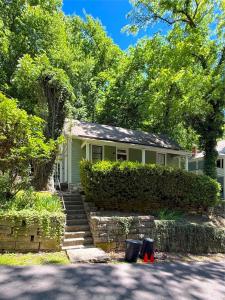 a green house with stairs in front of it at Cricket Cottage in Eureka Springs