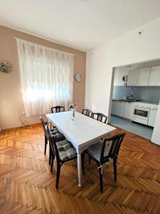 a table and chairs in a room with a kitchen at L&M Apartman in Virje