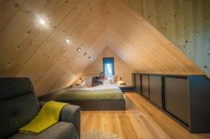a man is sitting on a bed in a room with a pointed ceiling at Green House - why not in Kismaros