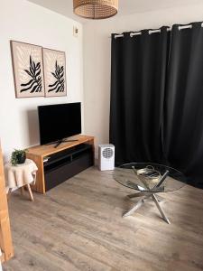 a living room with a glass table and a television at Apparemment jacuzzi balnéo centre de Bordeaux in Bordeaux