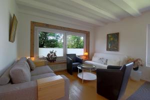 a living room with a couch and chairs and a window at NS 6 Möwenkoje Wremen in Wremen