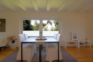 a dining room table with white chairs and a window at NS 6 Möwenkoje Wremen in Wremen