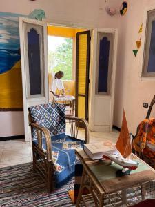 a living room with a couch and a table with a laptop at Nubian Kingdom Aragheed House in Aswan +100 photos