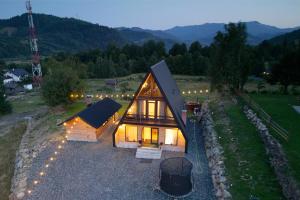 an overhead view of a small wooden house with lights at Cabana Magia Muntelui in Prisaca Dornei