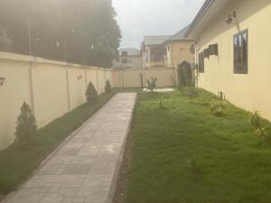 a backyard with a grassy yard next to a house at The Vicarage in Lashibi